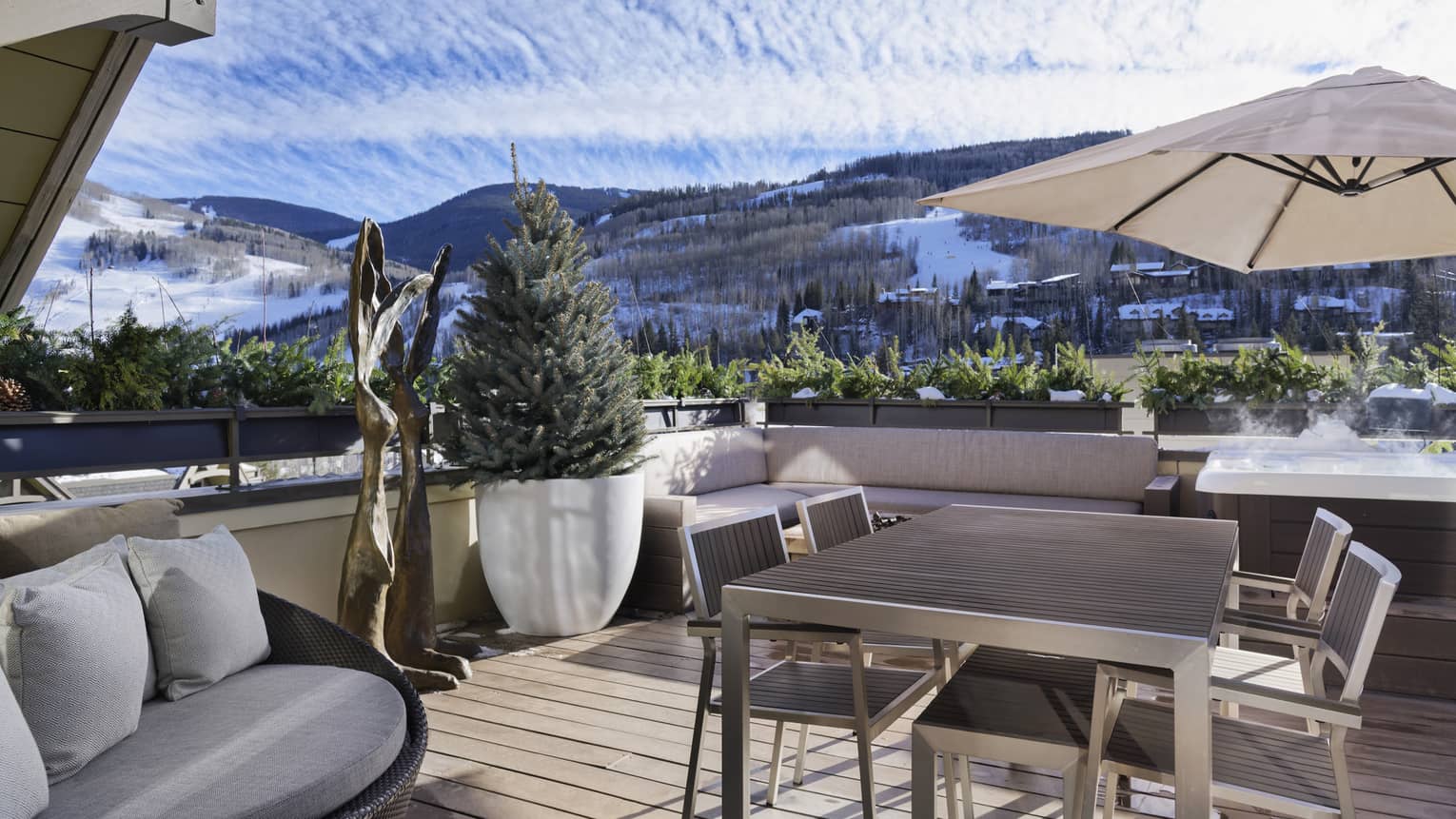 Wooden deck with dining table and four chairs, lounge chair, mountain views