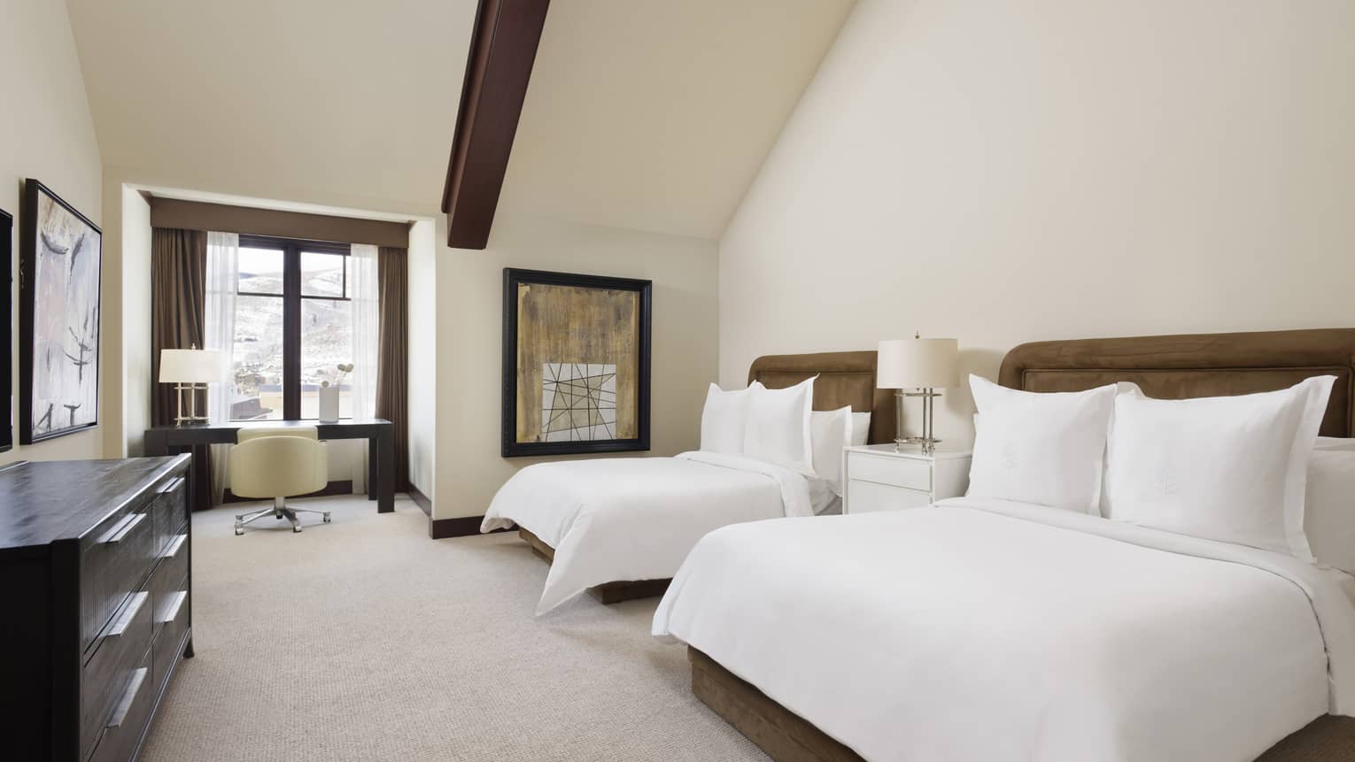 Bedroom with two double beds, wooden beam ceiling, desk and dresser