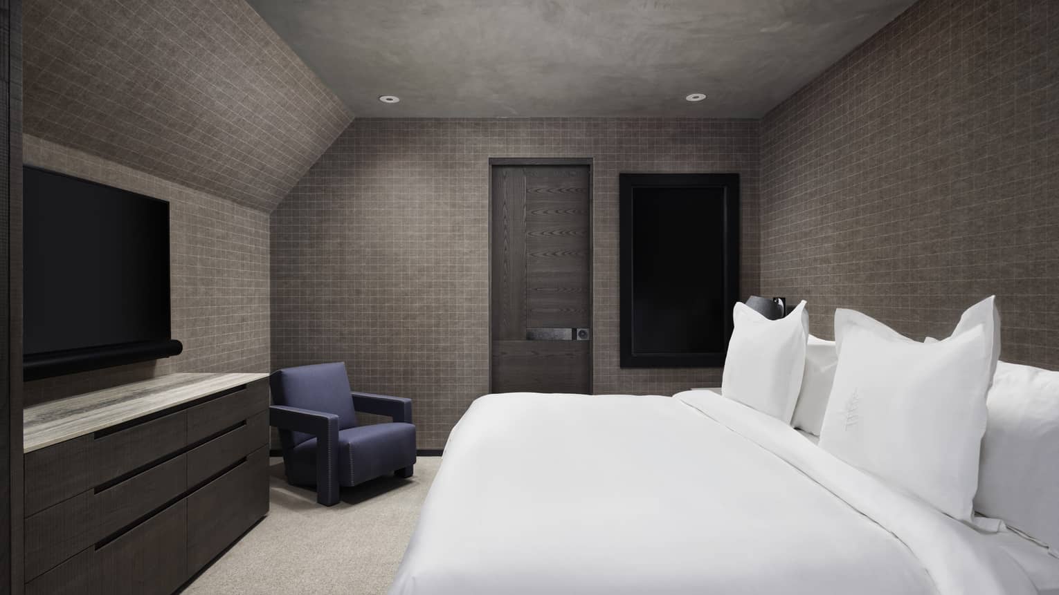 Bedroom with dark walls, white king bed, dresser and TV