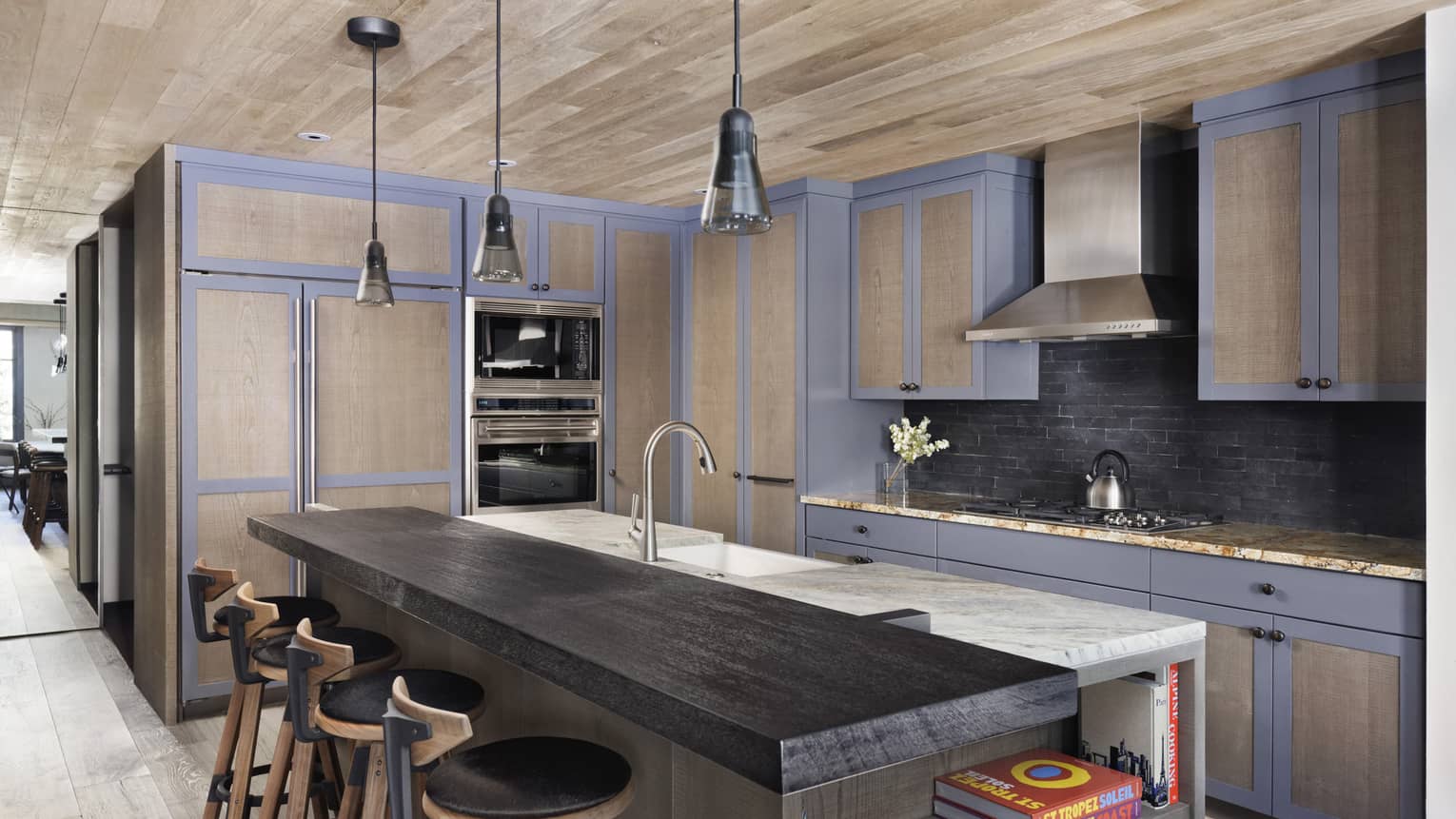 Mountain chic kitchen with wooden island counter, three stools