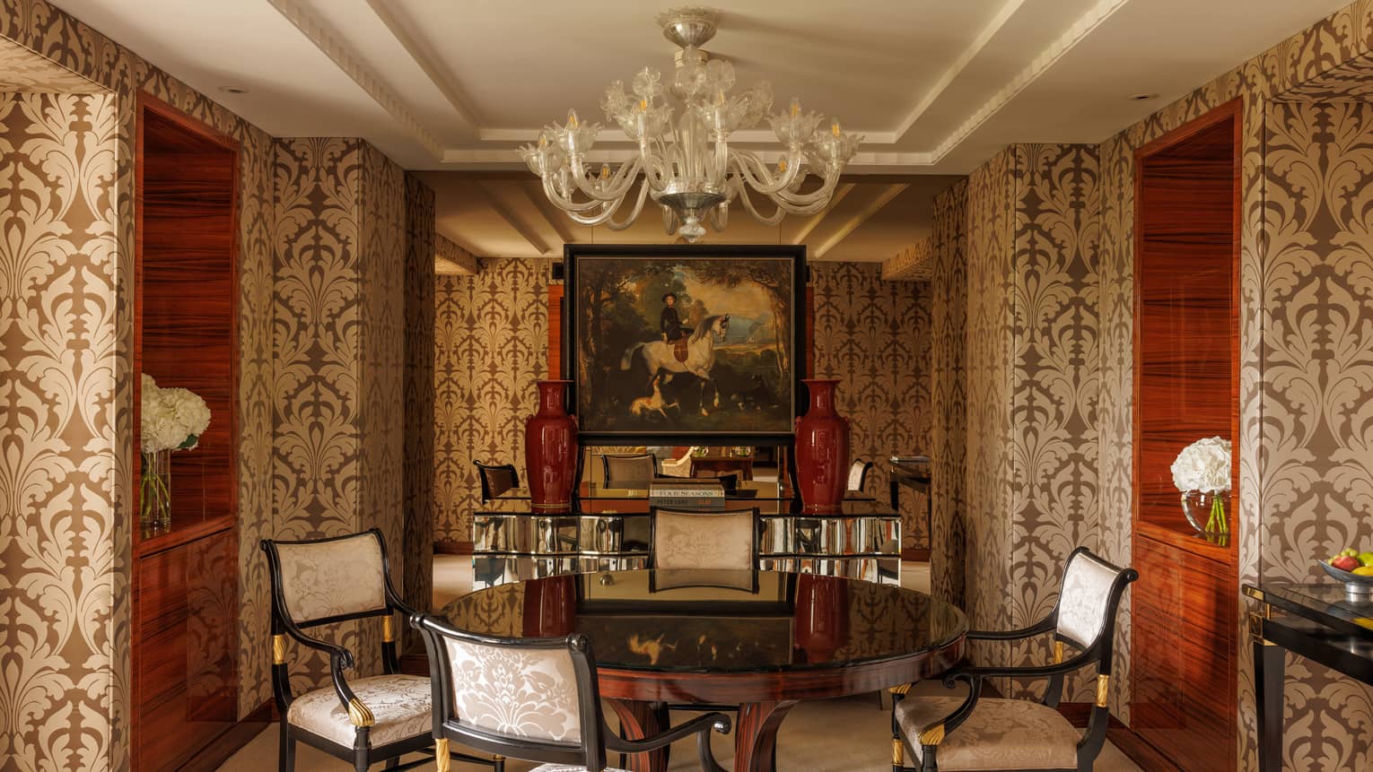 Presidential Suite dining room featuring wall-papered walls, round table and four upholstered chairs, at Four Seasons Hotel London