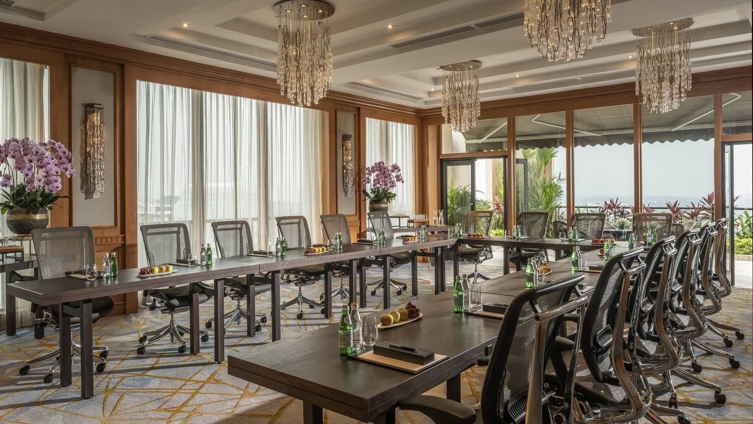 A bright room has chairs and tables arranged for a meeting