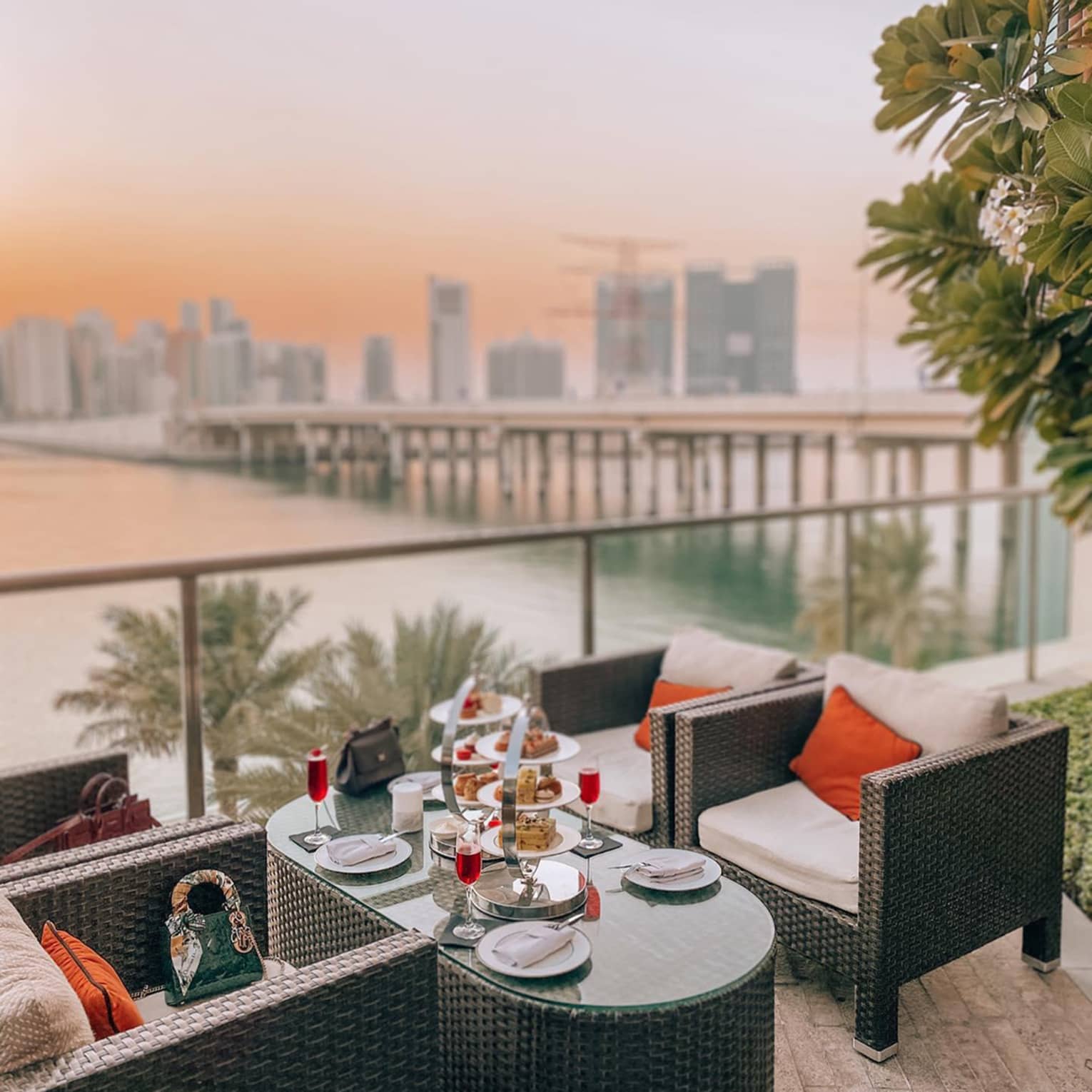 Patio armchairs and small table with dessert platter, cocktails on balcony