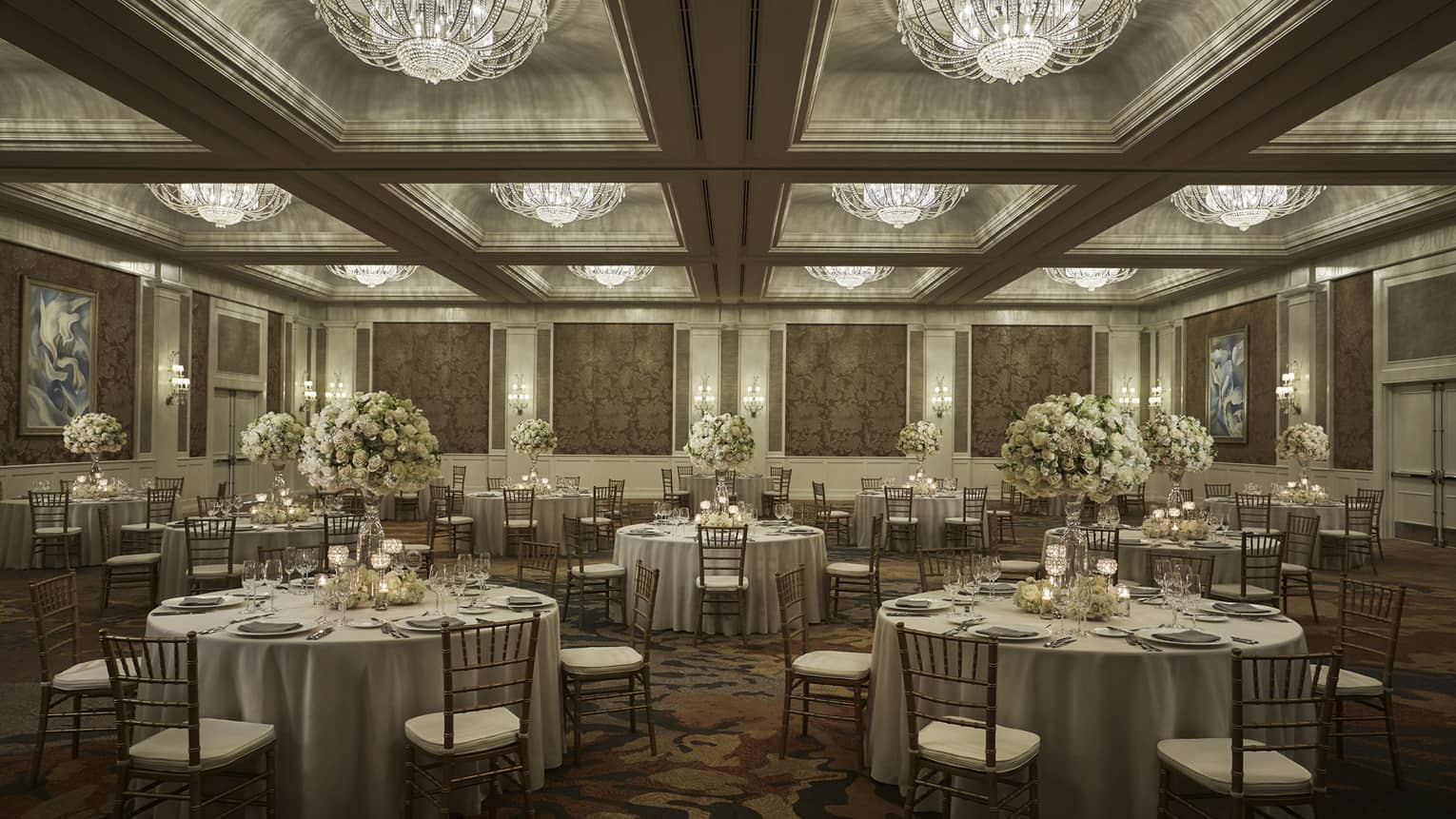 Round tables under crystal chandeliers in elegant Ocean Ballroom event space 