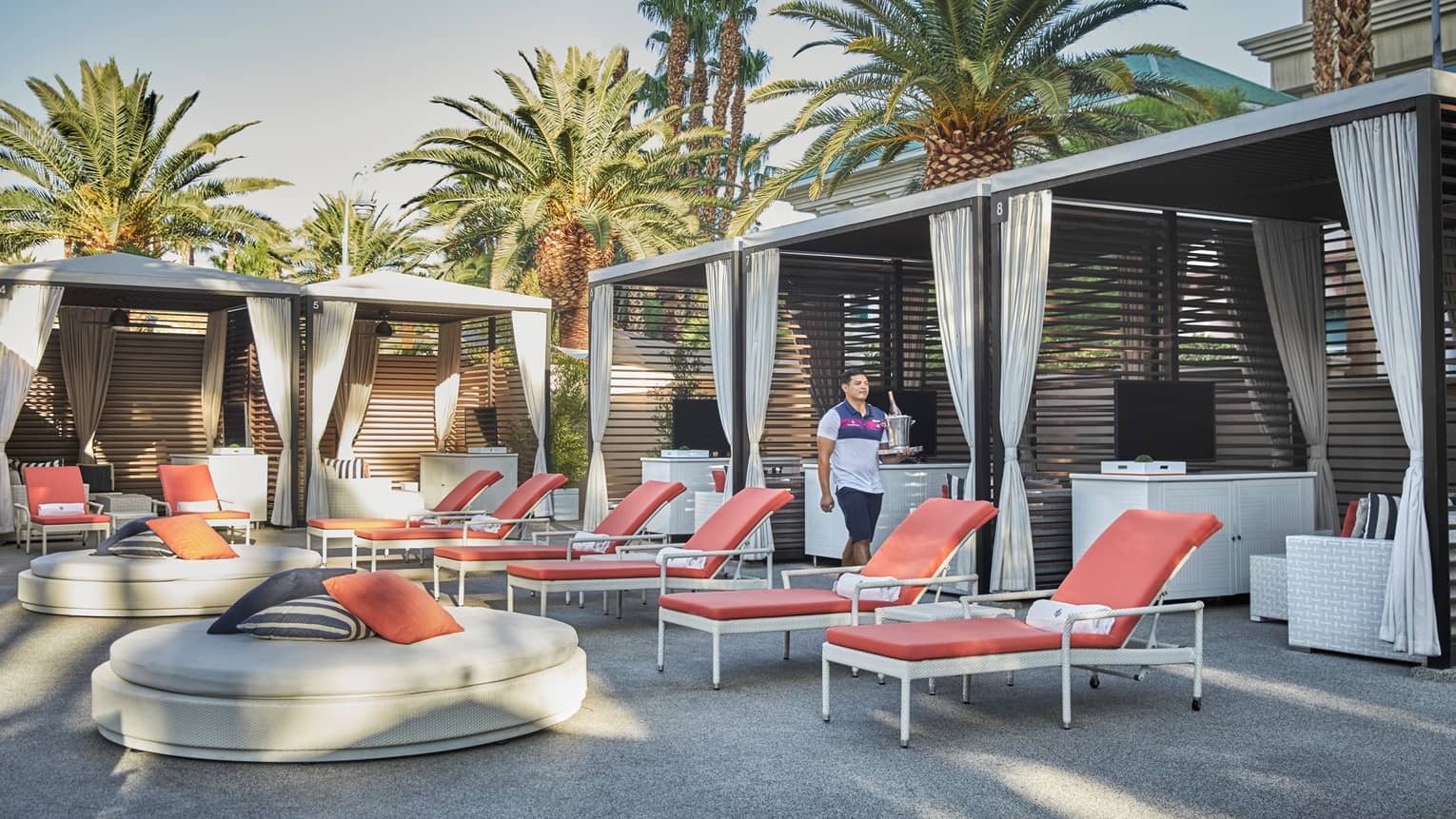 Lounge chairs, large foot stool and pool cabanas on deck