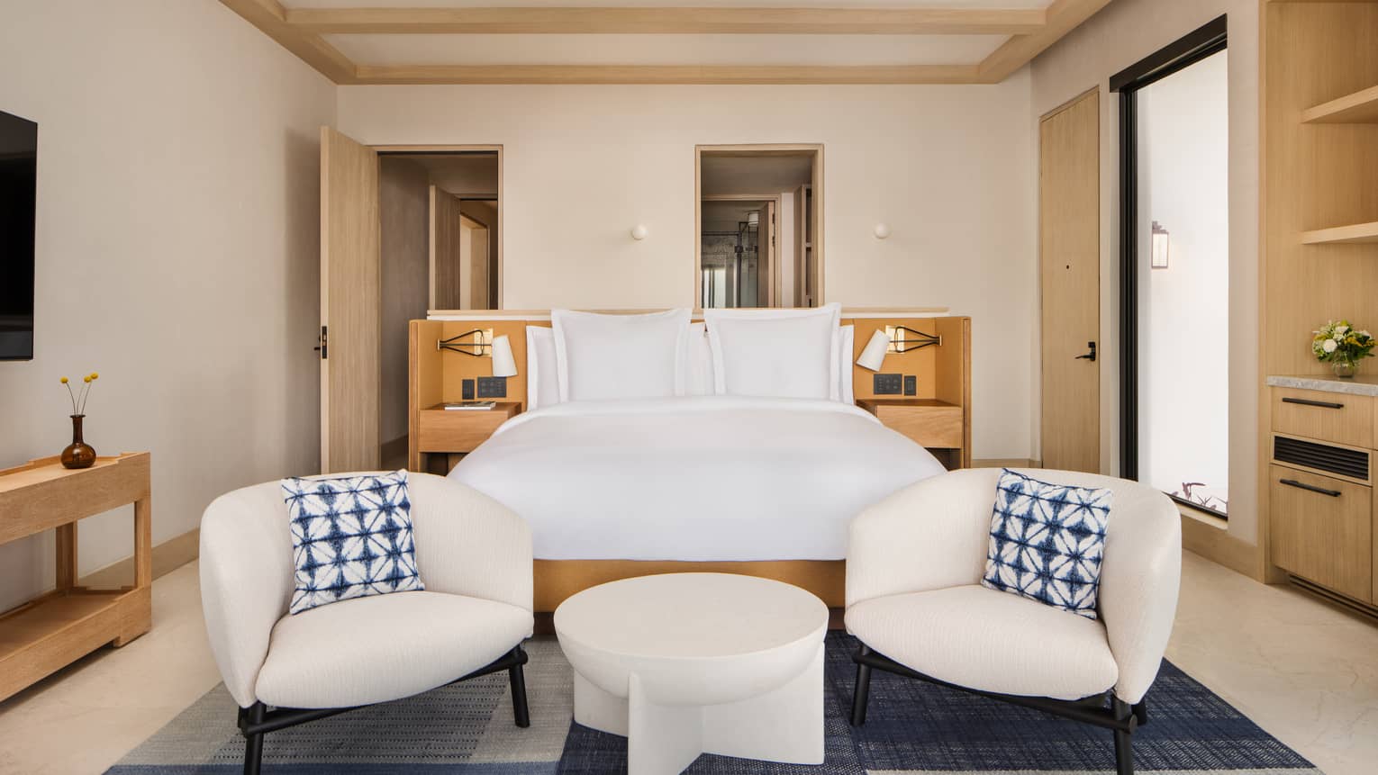 Luxury resort villa bedroom with king bed, two chic chairs and small table, at Four Seasons Resort Cabo San Lucas at Cabo Del Sol