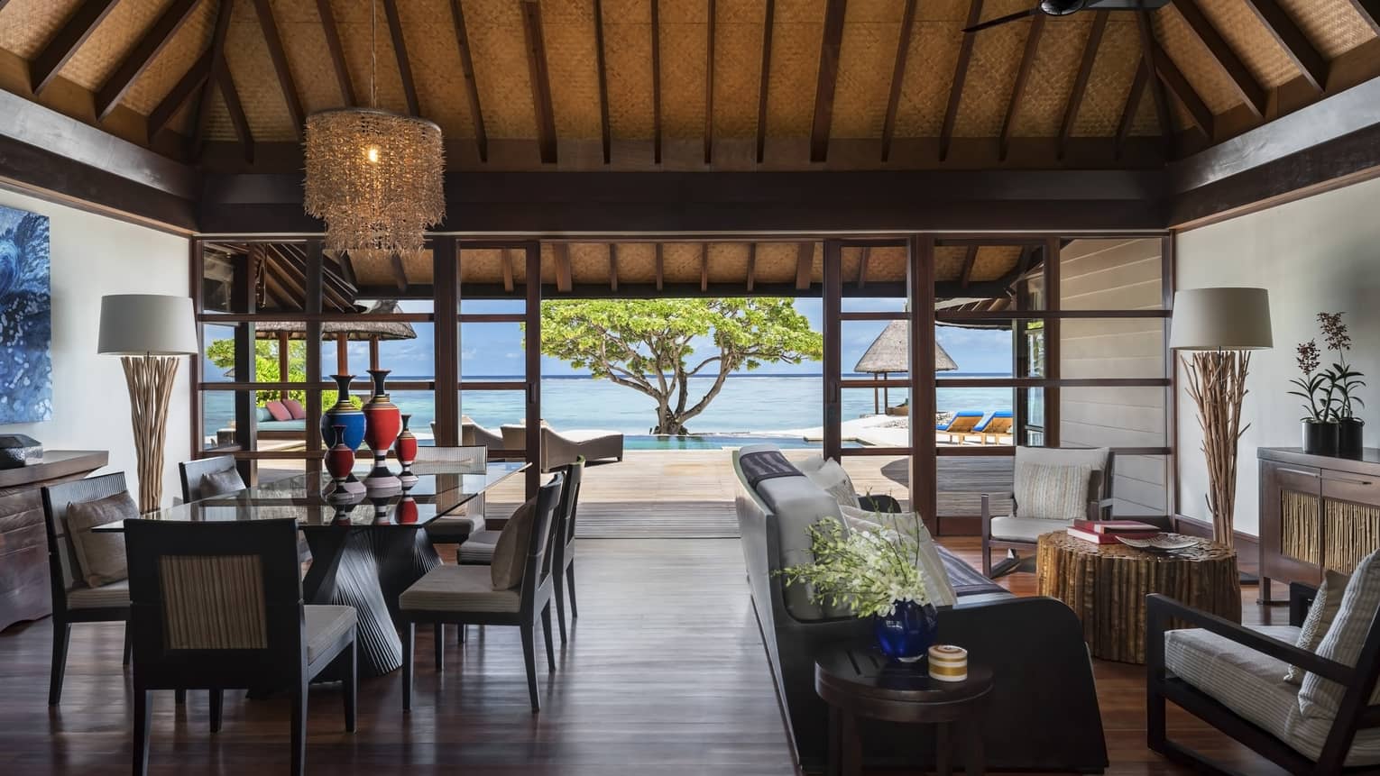 Wood-floored living room, opening up to the beach, of a Two-Bedroom Royal Beach Villa