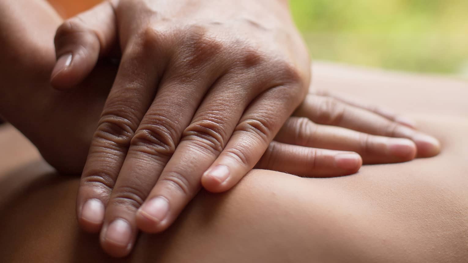Close up of hands massaging a back