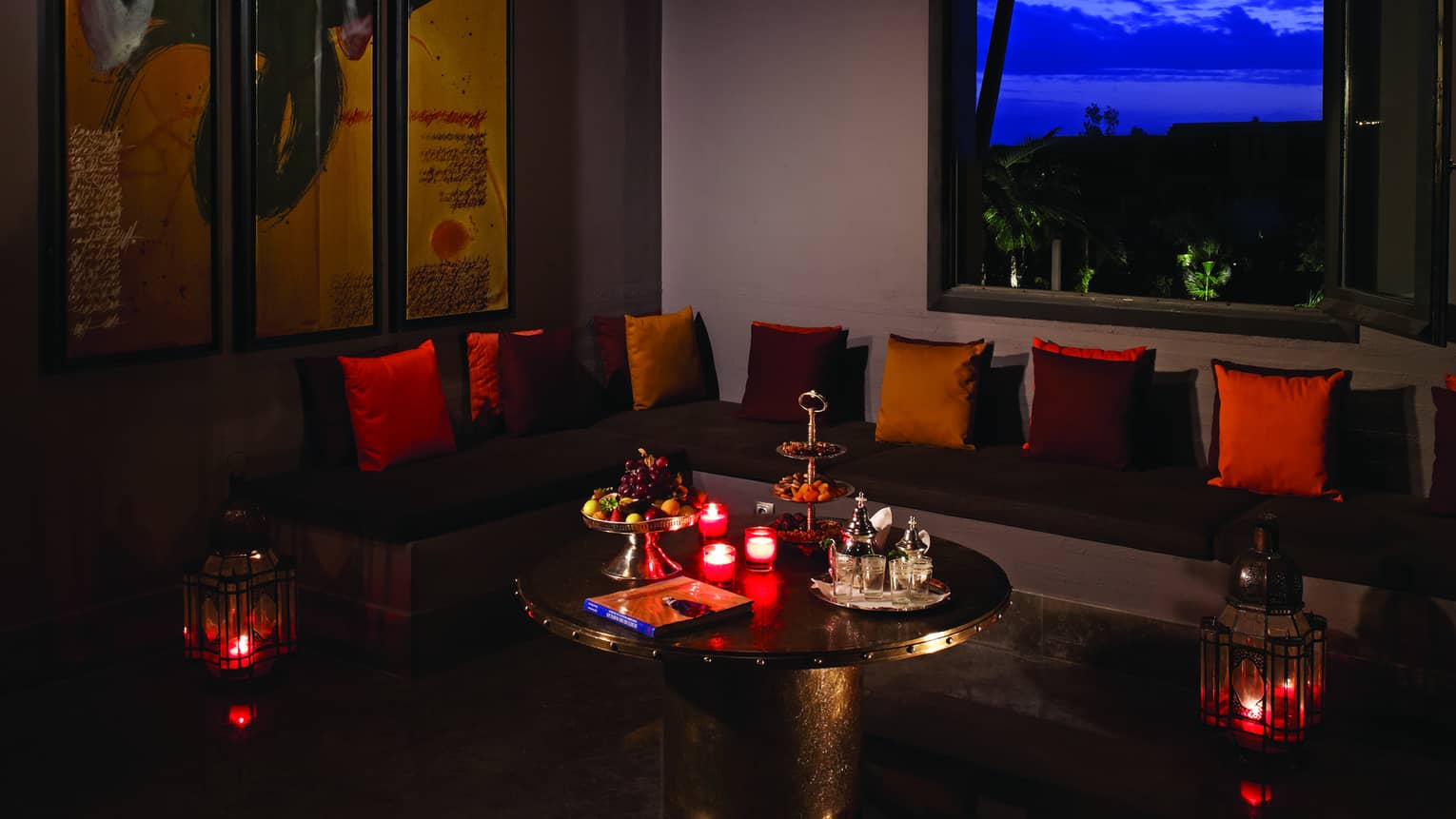 Bleu l'Orange tiered lantern above dark lounge with red cushions and candles 