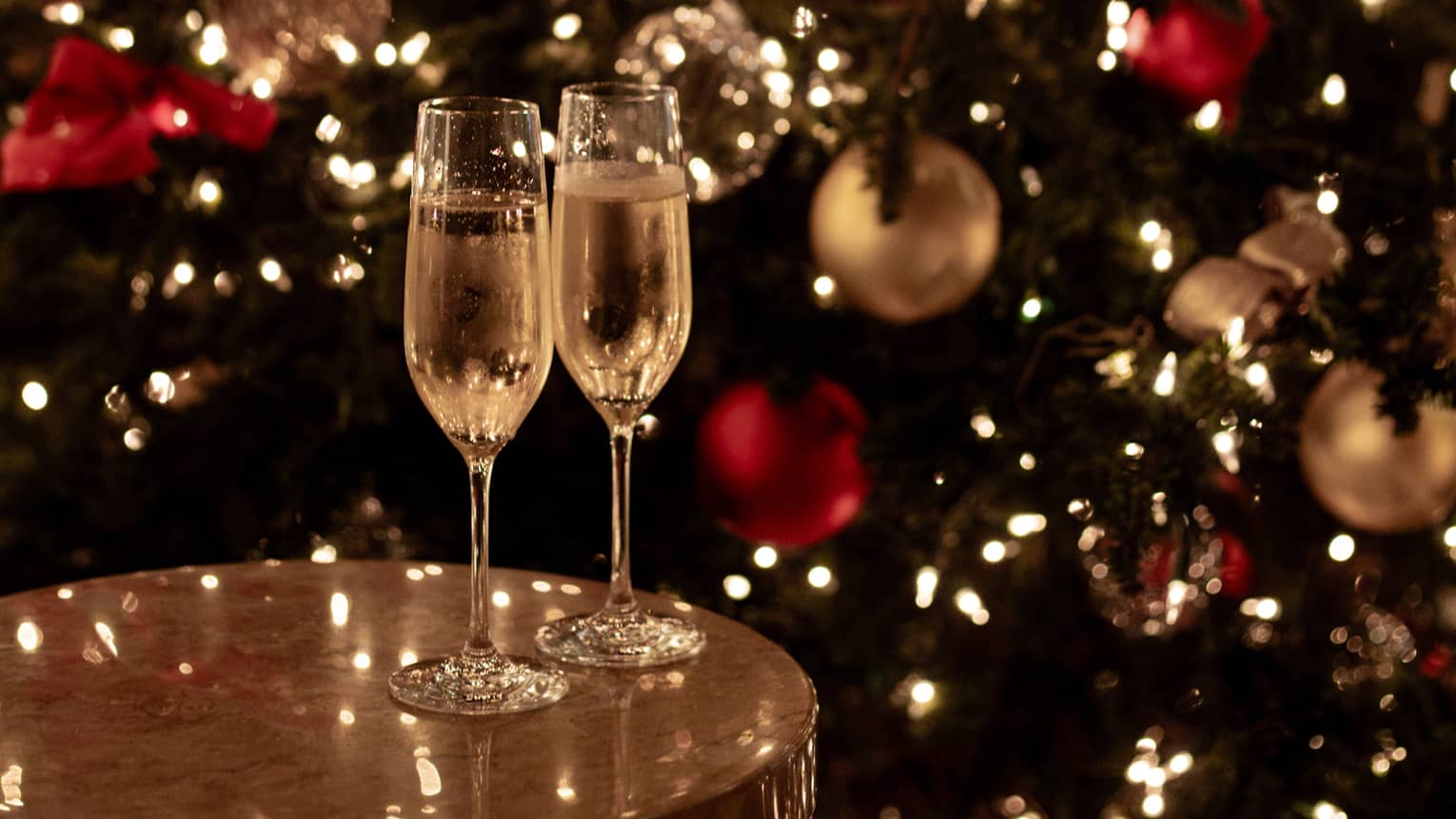 Joyous champagne toast with festive lights for Tokyo Christmas and New Year’s Eve celebrations.