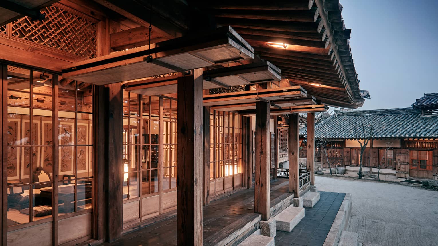 Korea Furniture Museum exterior, cement steps, rustic wood pillars outside windows with wood frames, lights