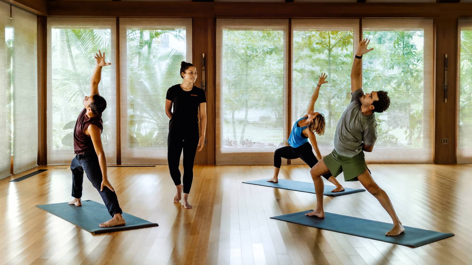 Yoga class with three people and instructor in soothing spa hale