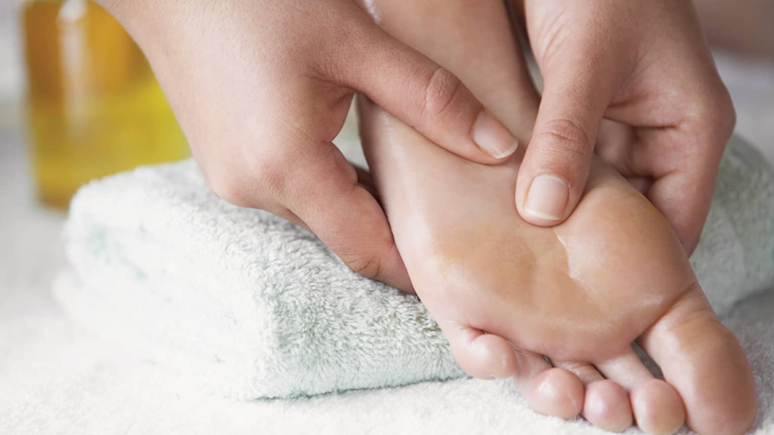 Close-up of hands massaging pressure points on feet