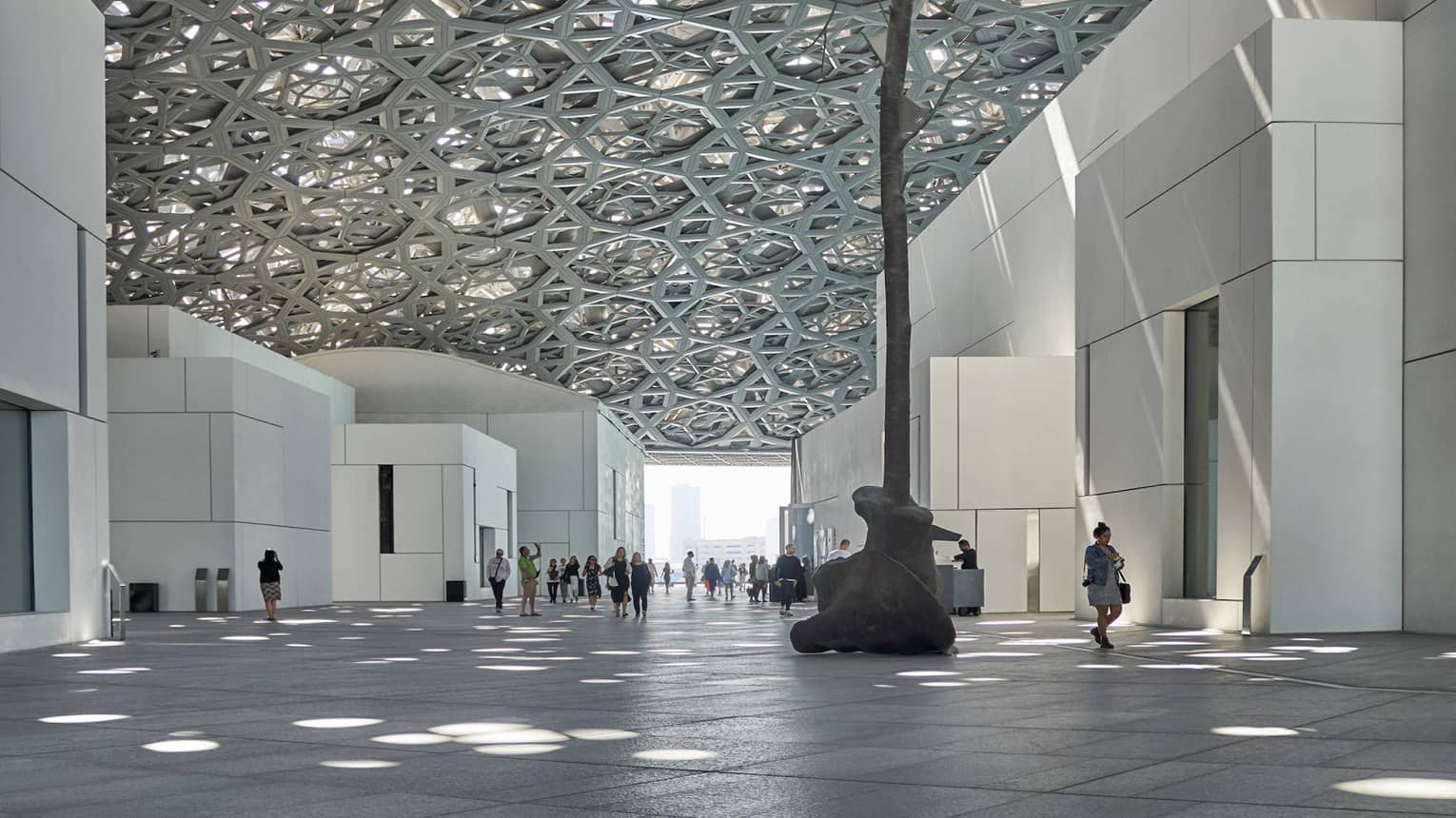 A large sculpture inside of a white stone building.