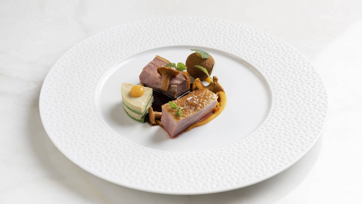 Duck confit on a white plate.