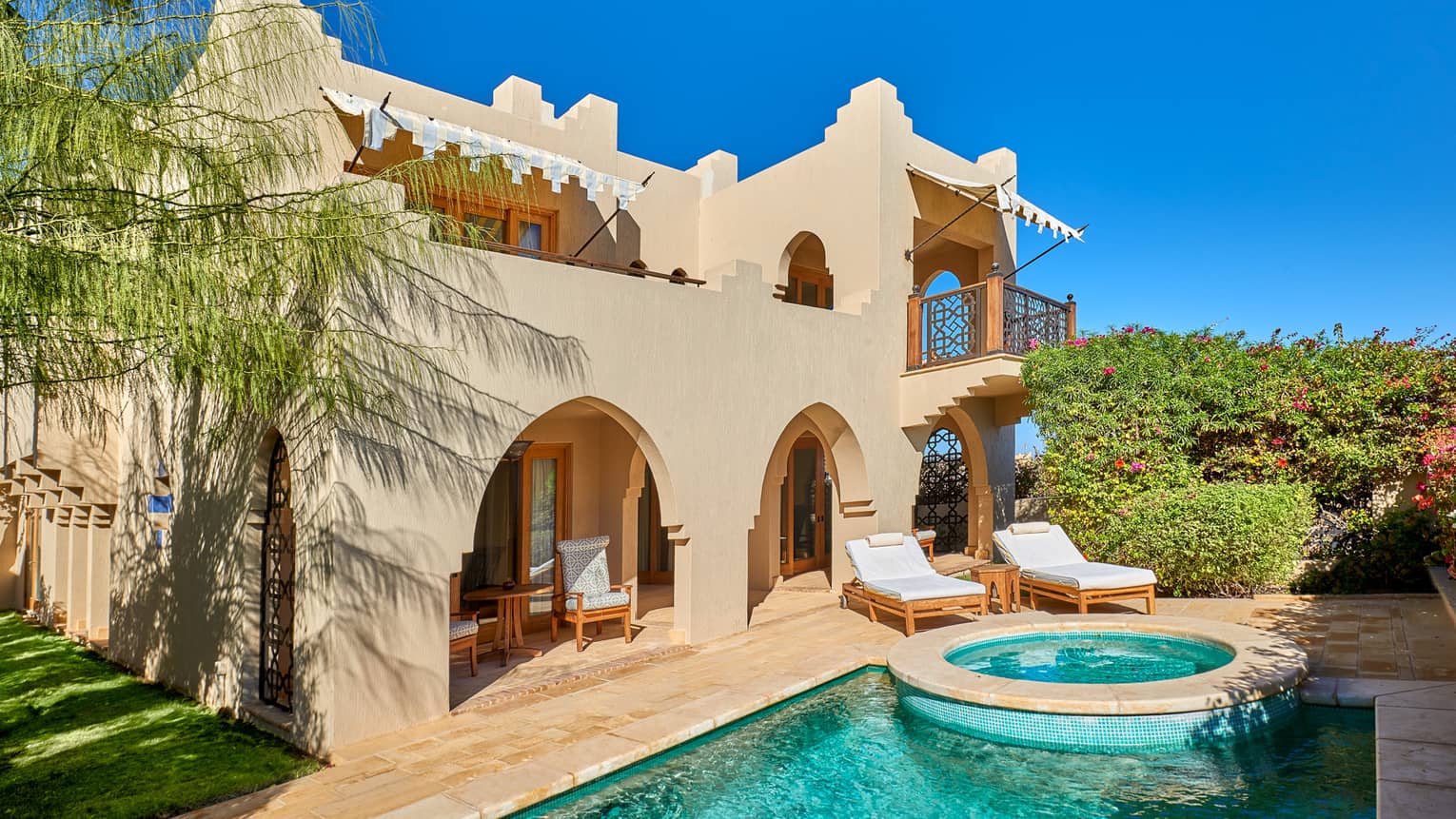 Exterior view of four bedroom villa and private pool against blue sky