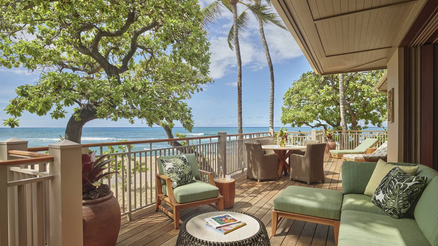 Private wooden lanai with tropical beach view, green sofa and chairs