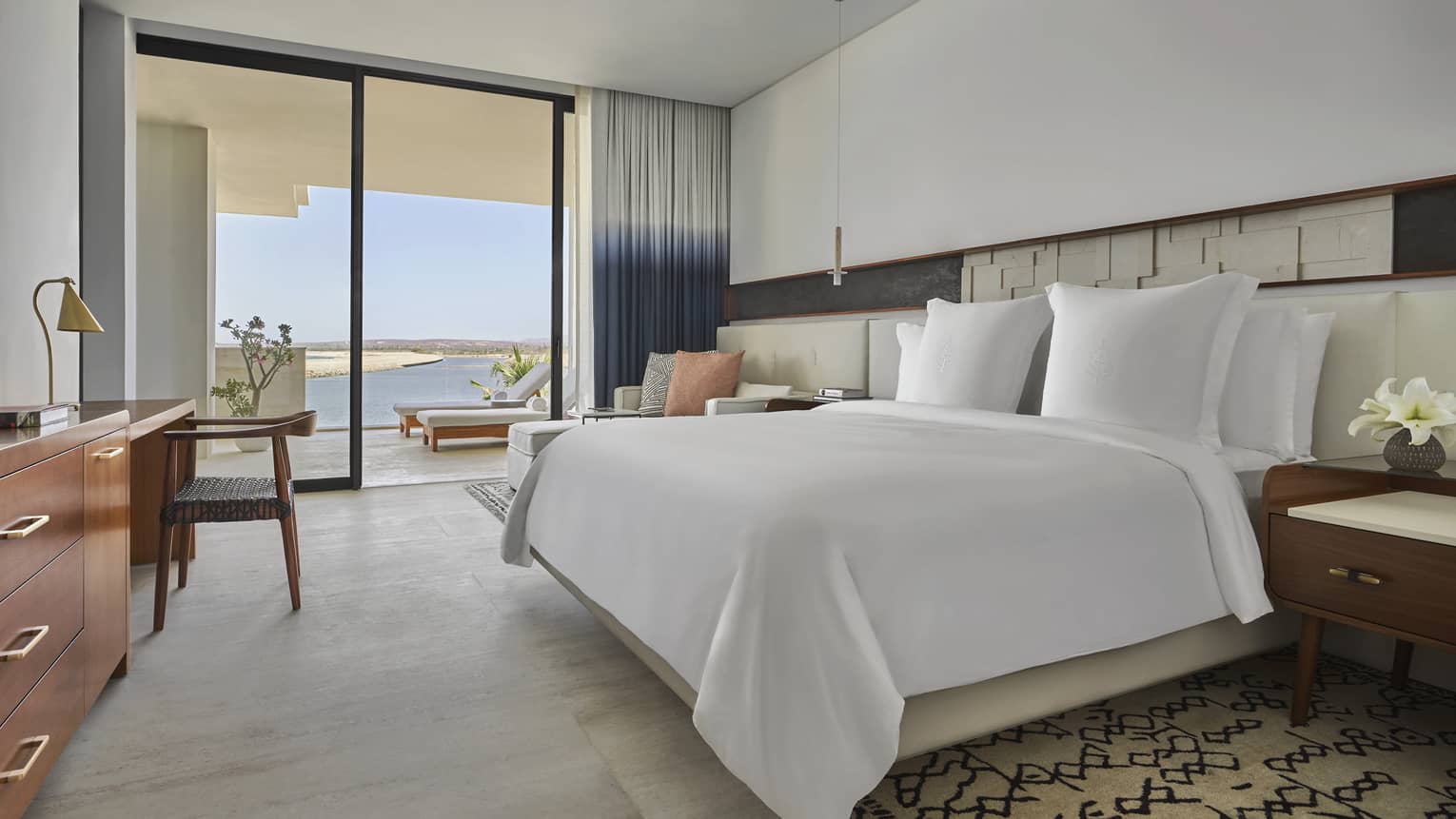 Bedroom with white king bed, walk-out terrace with sea view