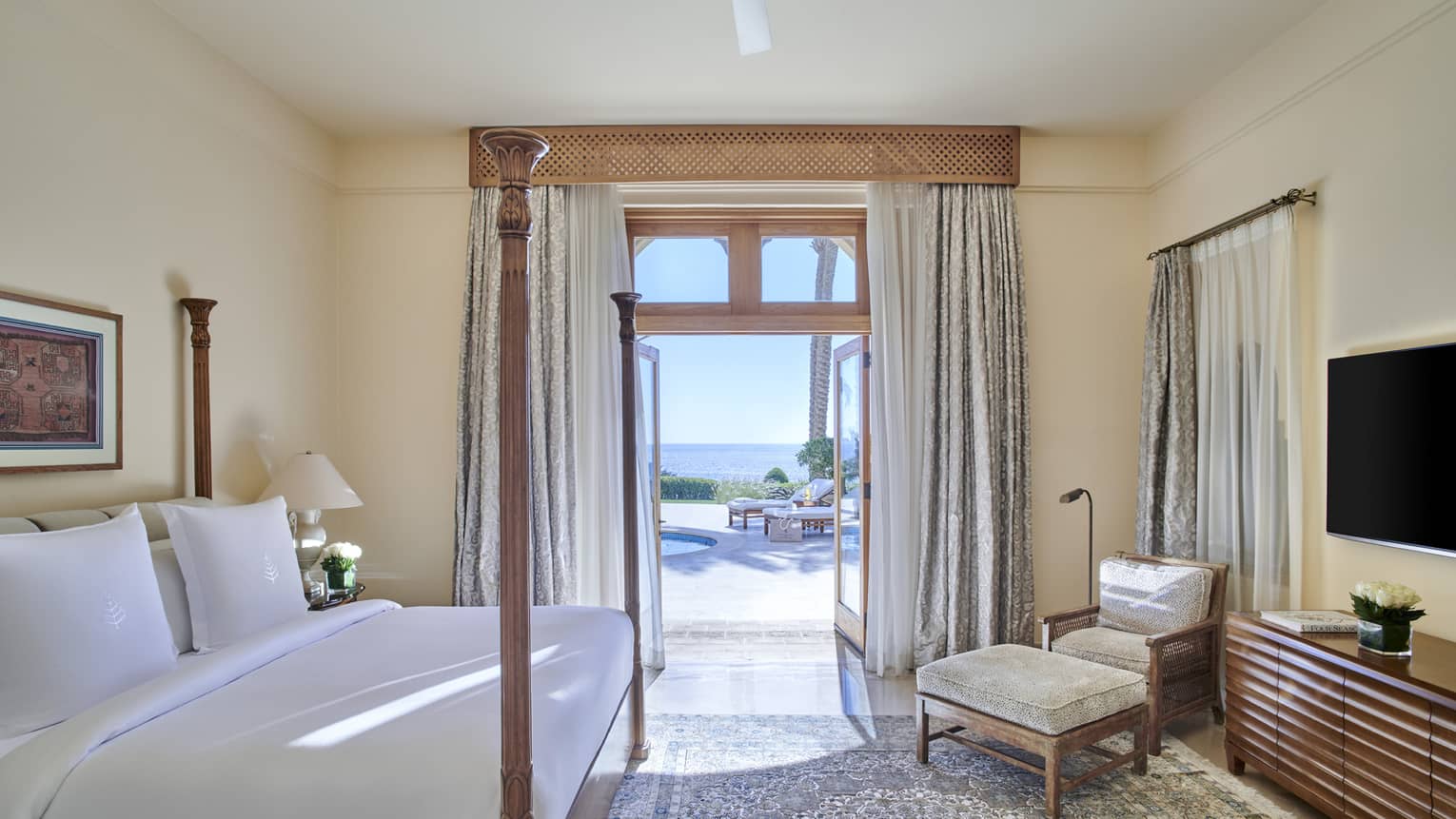 Bedroom with king bed, chair and ottoman, and walk-out terrace