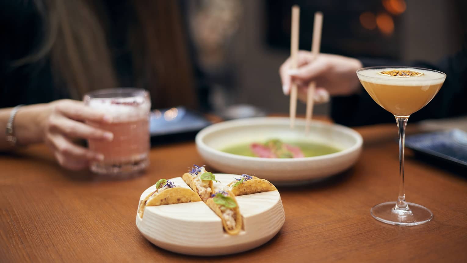 Accompanied by colourful cocktails, four small lobster tacos garnished with edible flowers nestle in a specially-shaped dish.