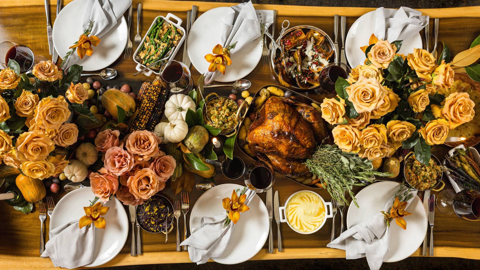 Overhead view of rectangular live-edge wooden table filled with a holiday feast