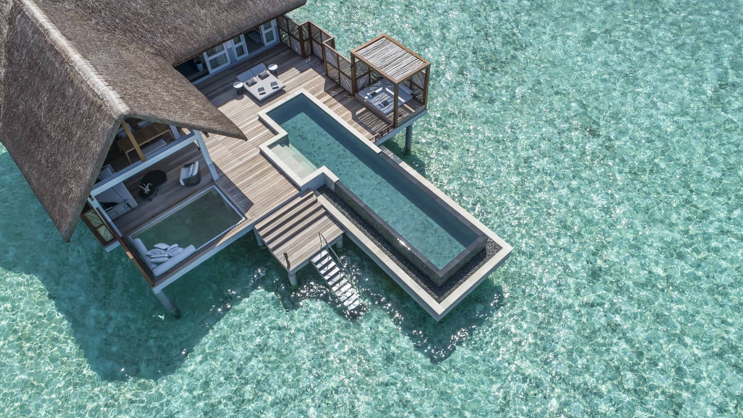 Aerial view of lure island villa with private pool and deck surrounded by crystal ocean
