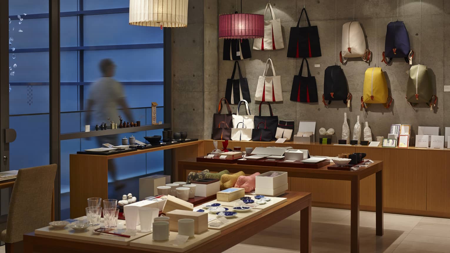 Kyoto Design Centre boutique retail store, wall with purses and backpacks, tables with pottery