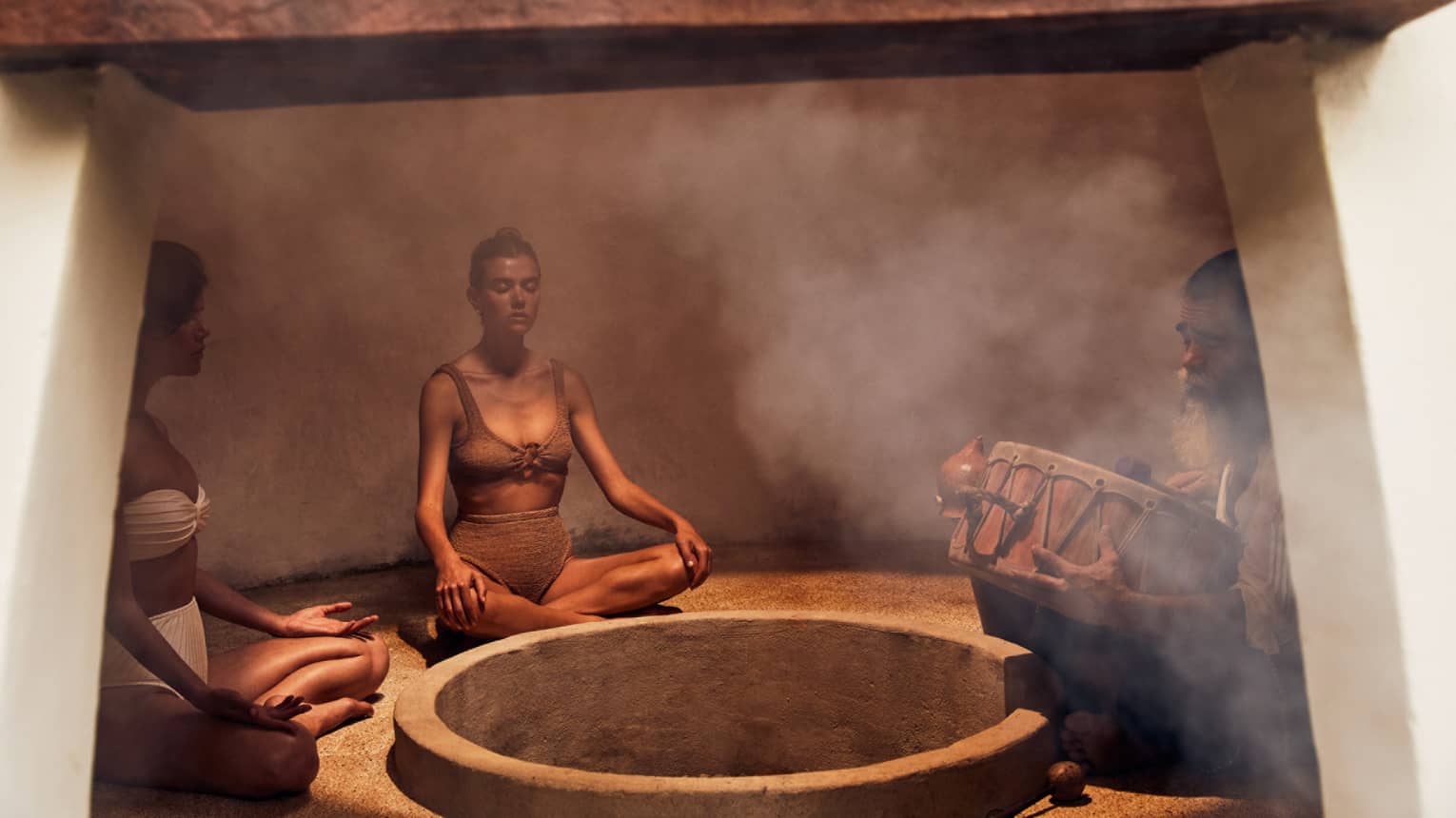 Three people sitting in a heated room with steam.