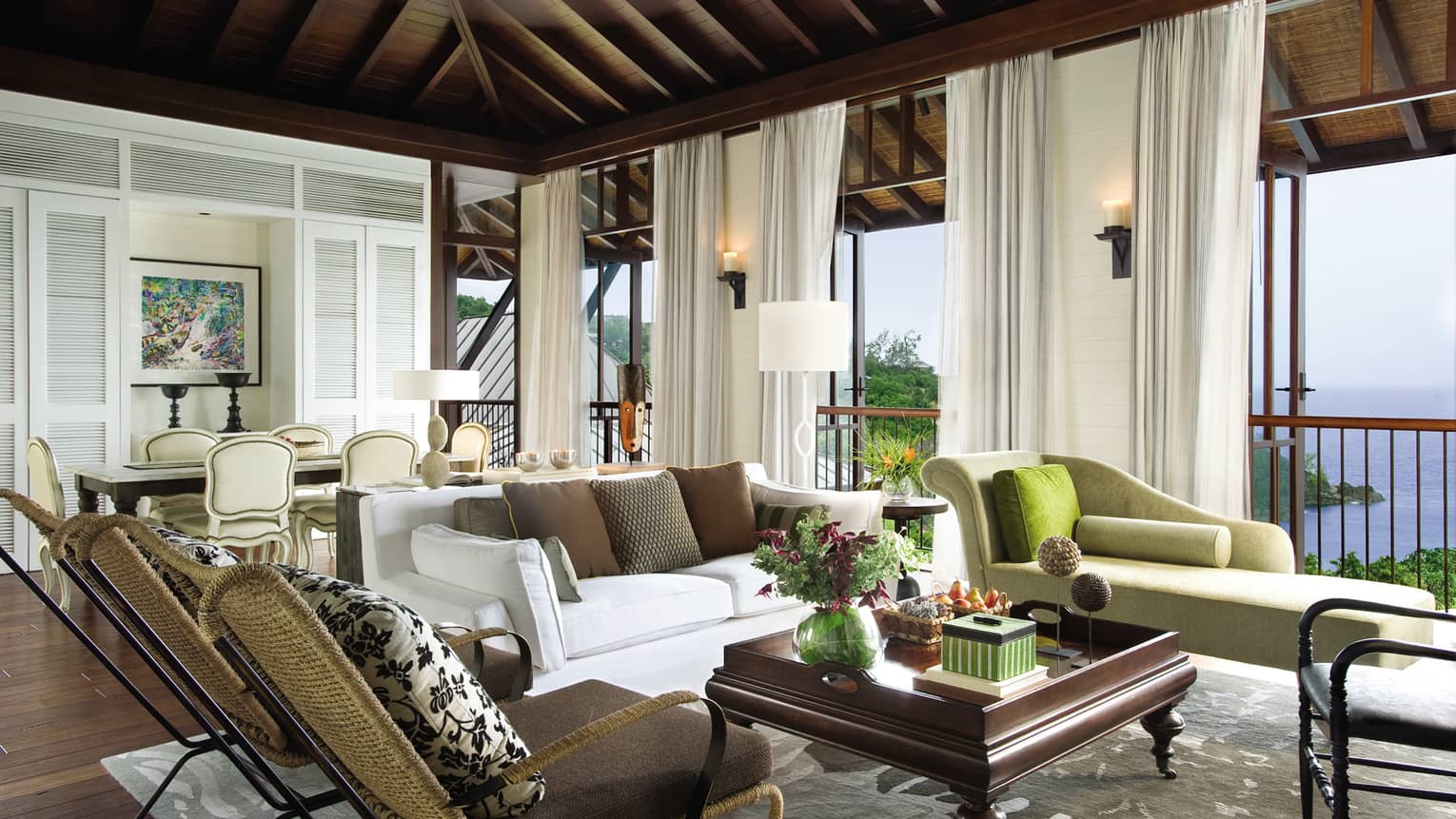 Two-Bedroom Ocean-View Suite living room with sofa, chaise lounge, two wicker chairs, open windows