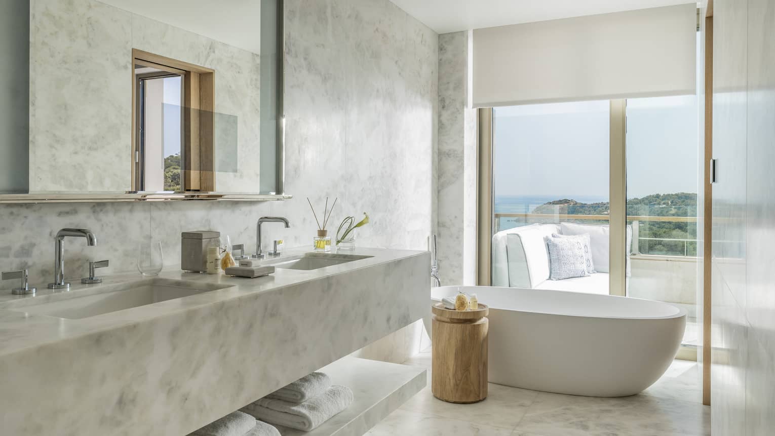 Arion Pine View Bathroom with marbled double vanity, full-width mirror, large soaking tub, ocean views