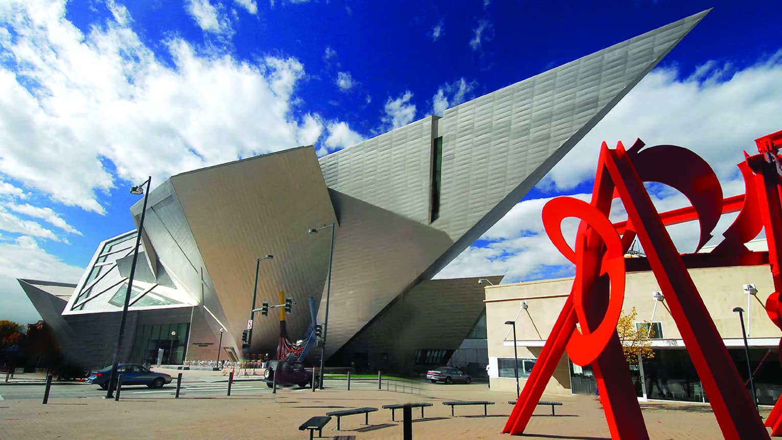 Modern, angular white exterior of Denver Art Museum, tall red sculpture