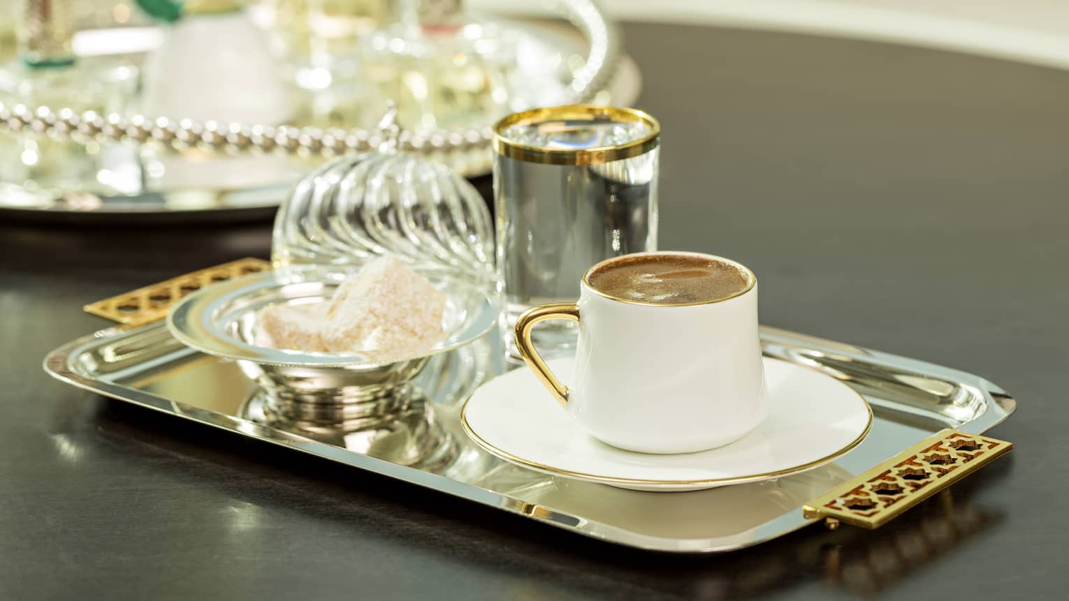 Al Meylas, close-up of elegant coffee tray with gold-rimmed cup and Turkish Delight sweets in bowl