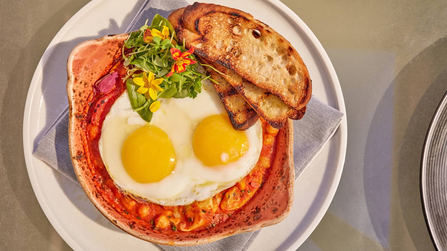 Eggs and toast on a red soup.
