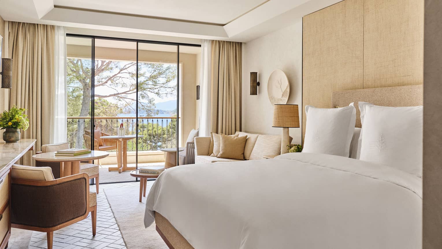 Luxury hotel room with king bed, windowside lounge seating and garden-view terrace at Four Seasons Resort Mallorca
