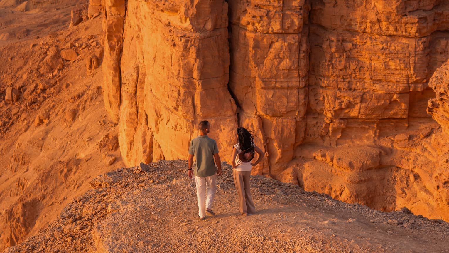 Two people walking in a desert landscape