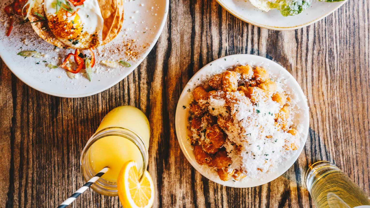 Aerial view of colourful assorted meals on top of a rustic wooden table