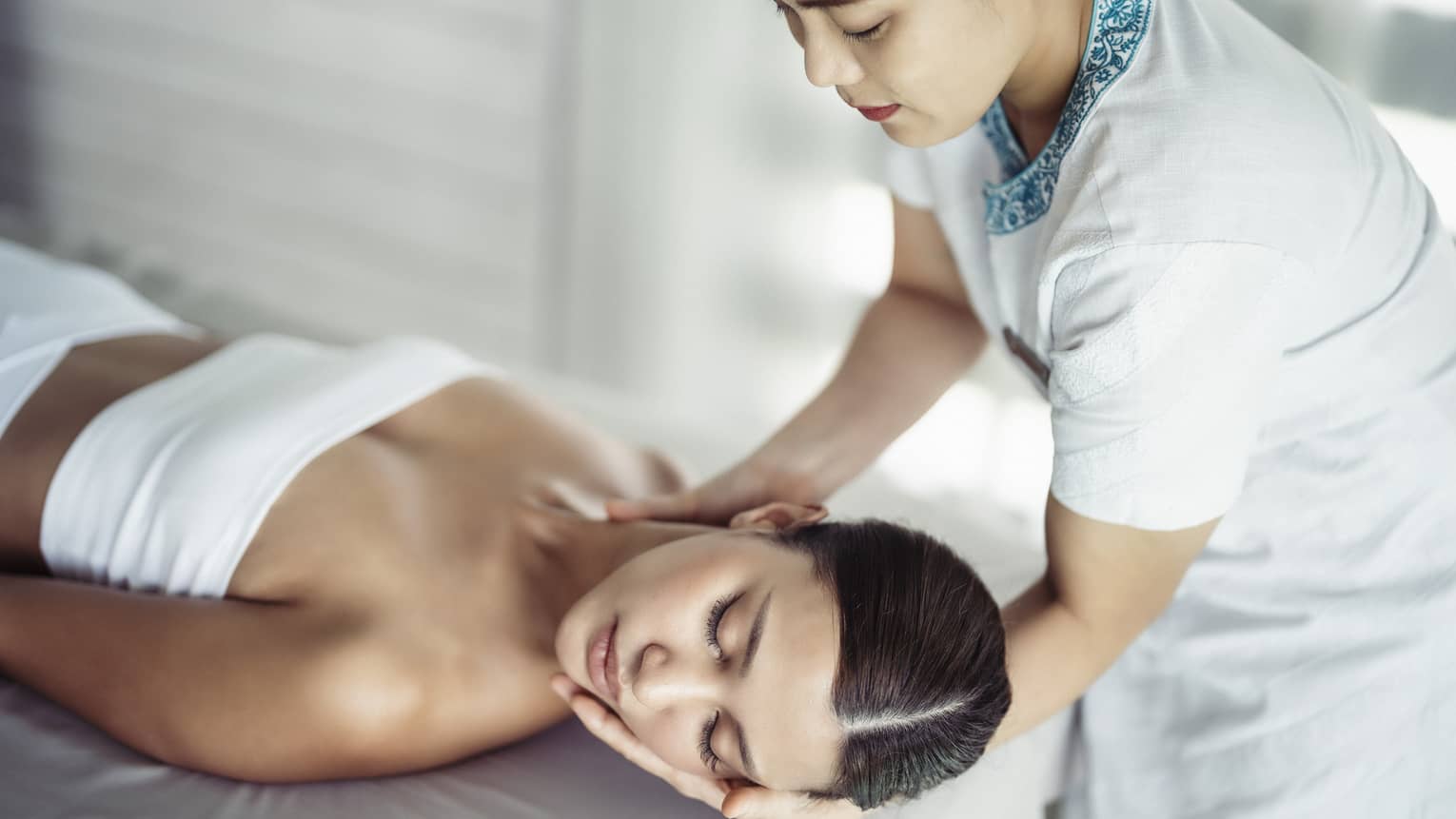 A woman in a spa receiving chiropracty.