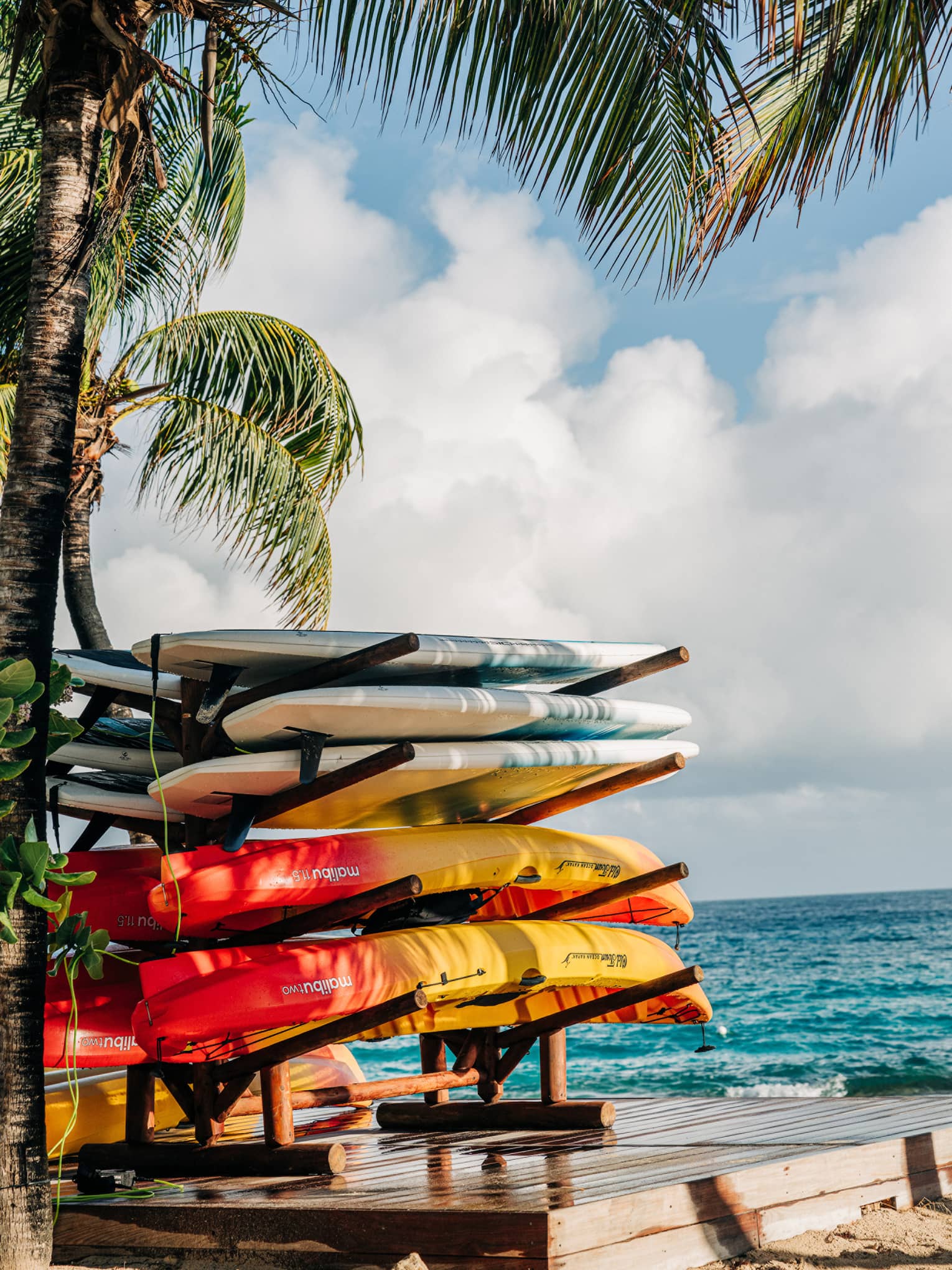 Kayaks stacked up on a tropical beach