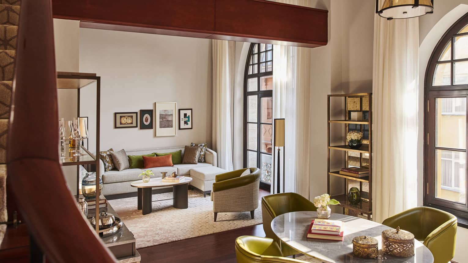 Hotel suite with neutral living room, large wooden beamed ceiling and contemporary round dining set