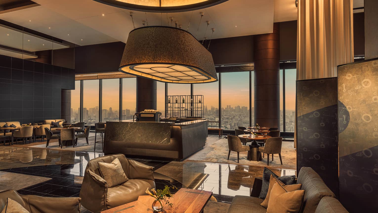 Contemporary hotel lobby lounge with city view at sunset