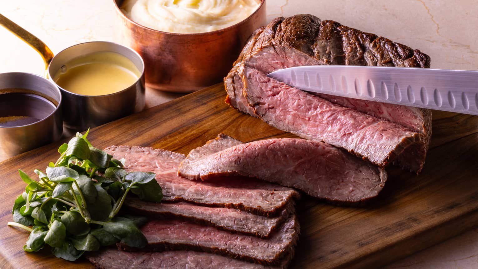 Japanese Wagyu beef on chopping board with accompanying sauces
