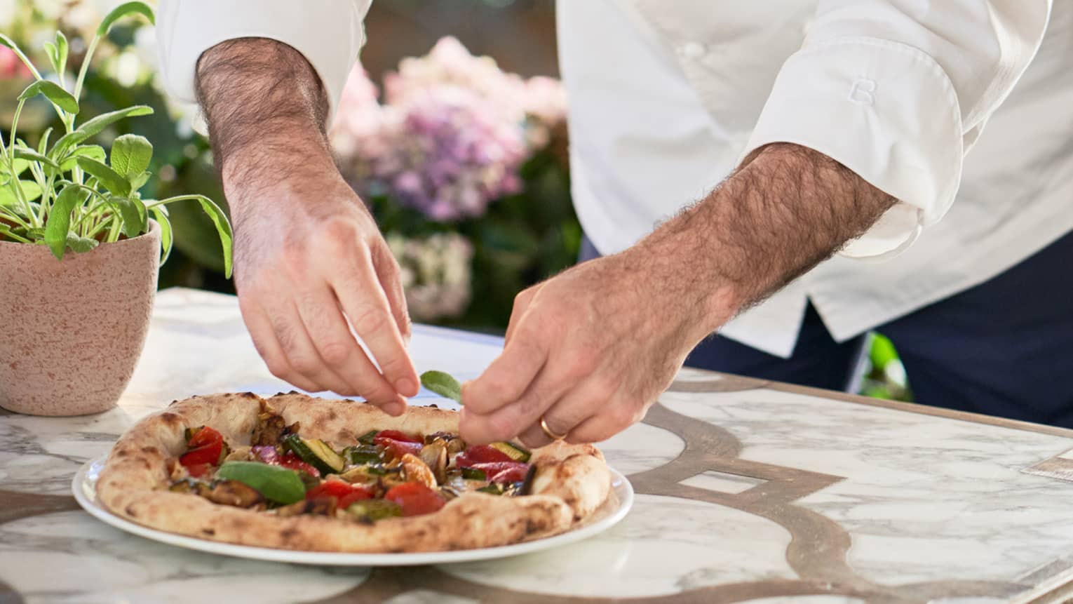 Vito Mollica, executive chef, delicately arranges toppings on a pizza