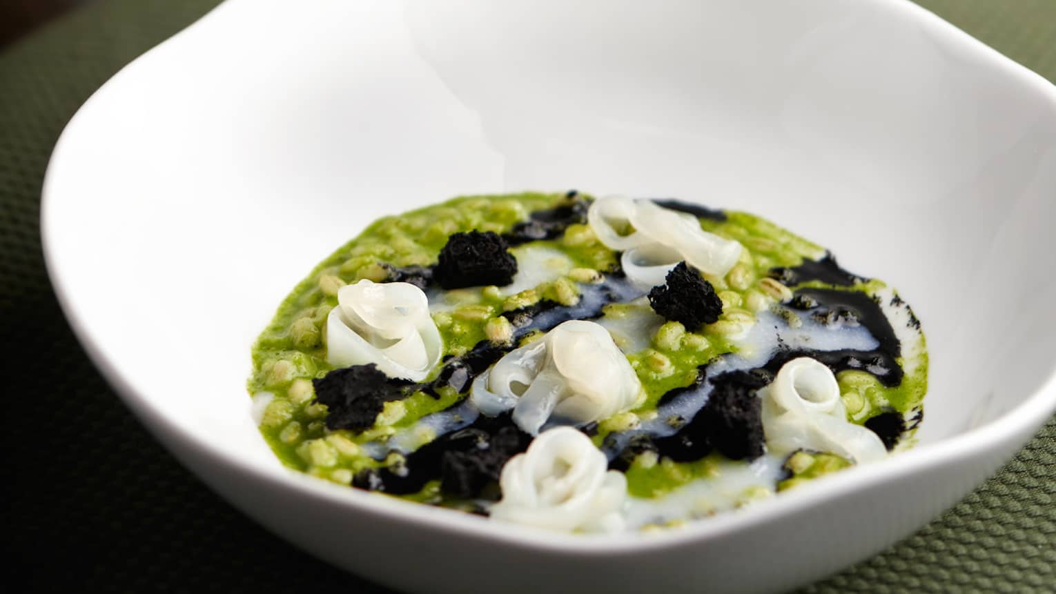 Cuttlefish and leafy greens in a bowl.