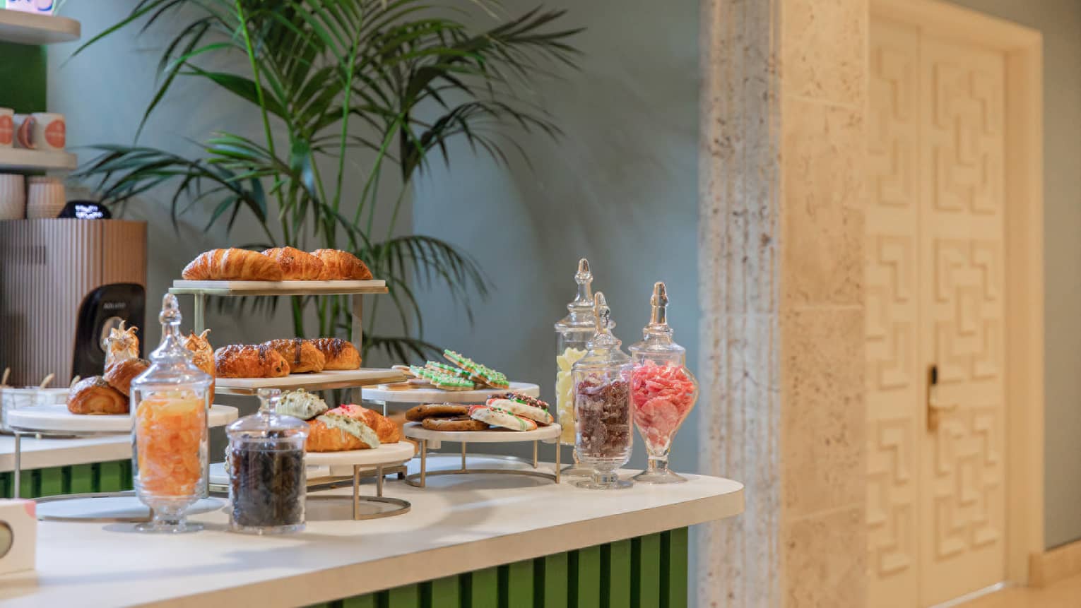 Counter topped with tiered trays of pastries and glass jars filled with colouful treats