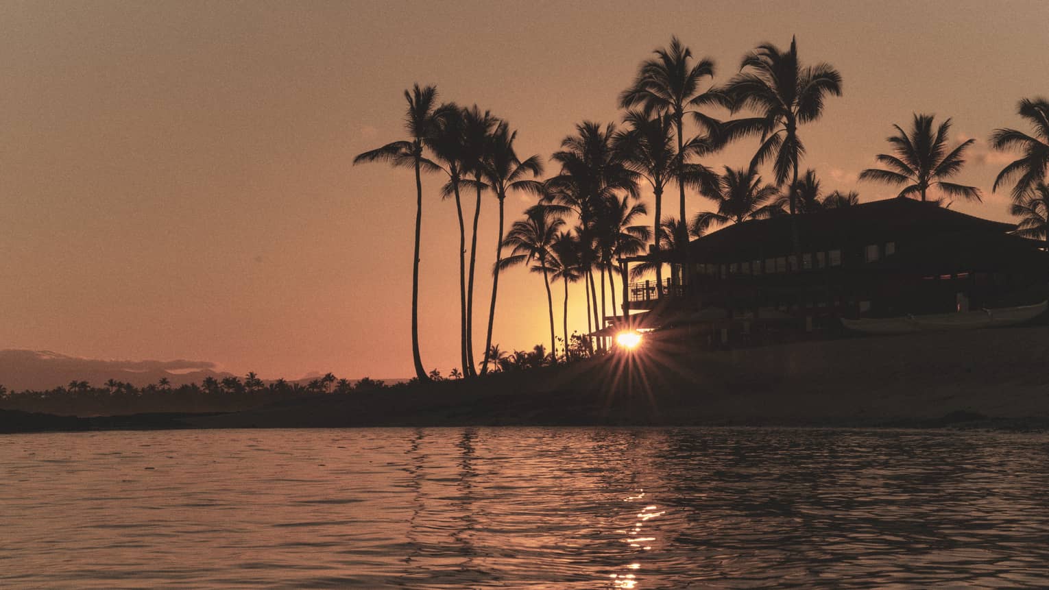 Tropical resort on the water at sunset
