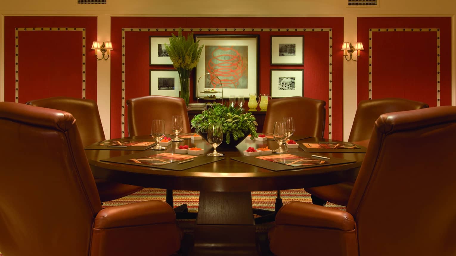 Six plush chairs surround a table set up for an intimate group meeting