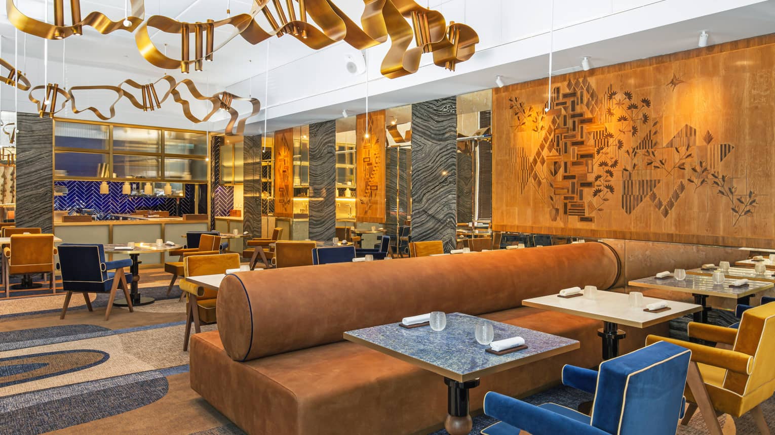 Modern dining area with gold, blue and deep camel accents and art flanking walls and ceiling