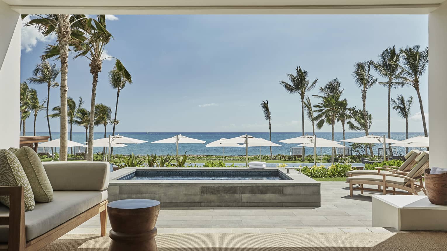 Pacific Suite open to wall to patio with stone plunge pool, lounge chairs, ocean views