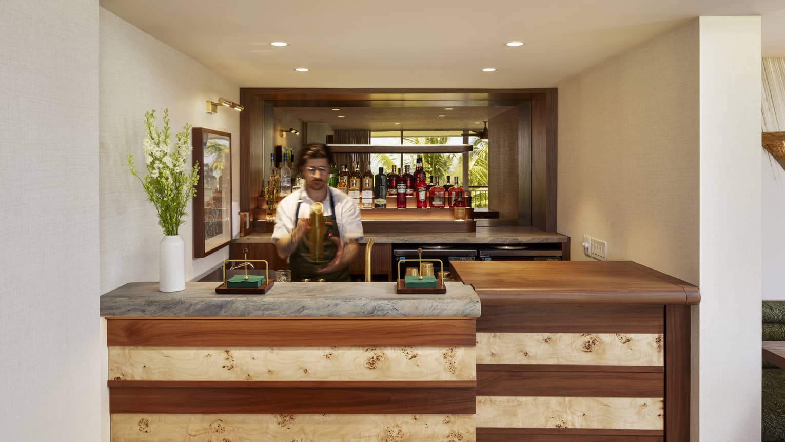 Bartender makes a drink behind a wooden bar counter