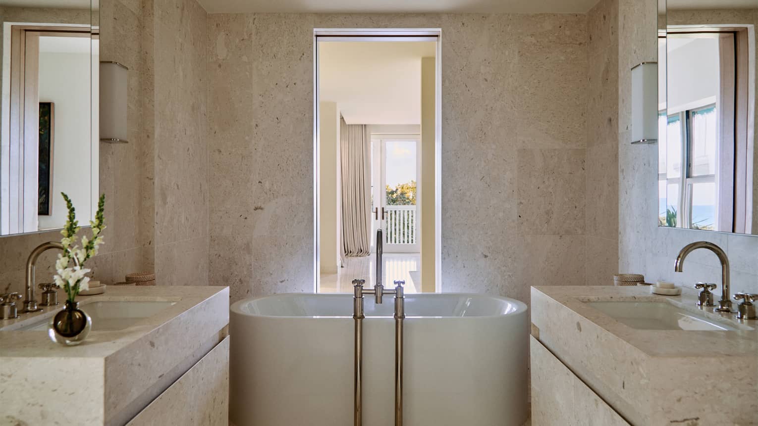 Luxury marble bathroom featuring a standalone deep soaking tub and a vanity on each side of the bathroom
